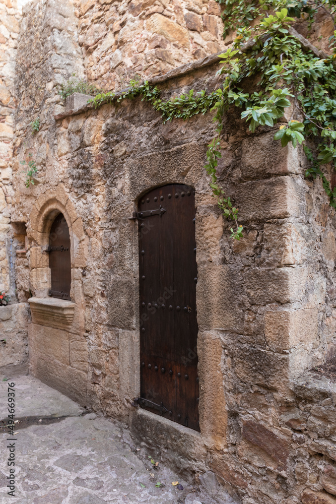 wooden door of an old building in the medieval village of pals on the costa brava