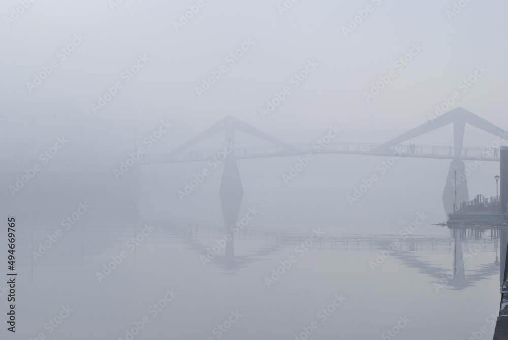 Fototapeta premium Bridge and Reflections in Still River Water on Misty Morning 
