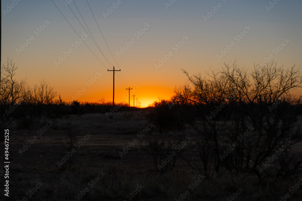 Power lines leading into the rising sun in rural Texas Power lines leading into the rising sun in rural Texas