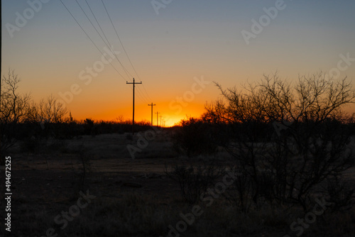 Power lines leading into the rising sun in rural Texas