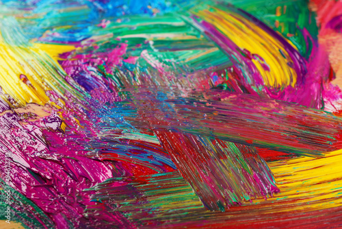 Closeup view of artist s palette with mixed bright paints as background