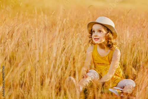 A happy child is sitting in the grass of a outumn meadow photo