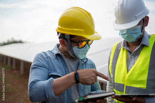 Engineers and technicians work to power solar panel renewable power plants.