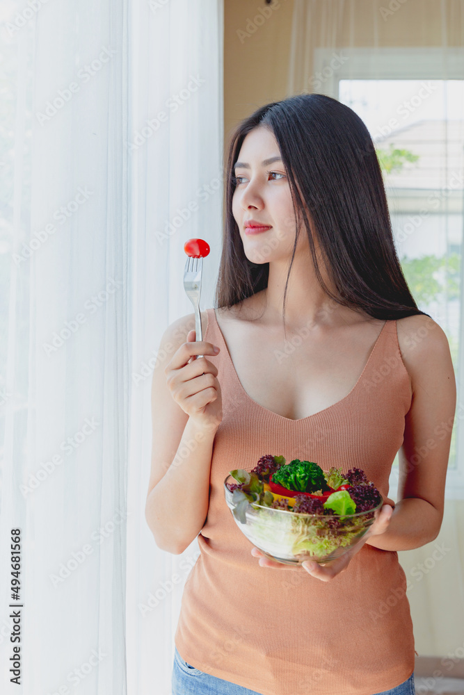 asian woman with healthy food,  Beautiful girl eating a salad in house, health care eat vegetables and useful foods lifestyles concept.