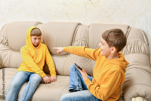 Canvas Print The older brother took the phone from the younger and laughs at