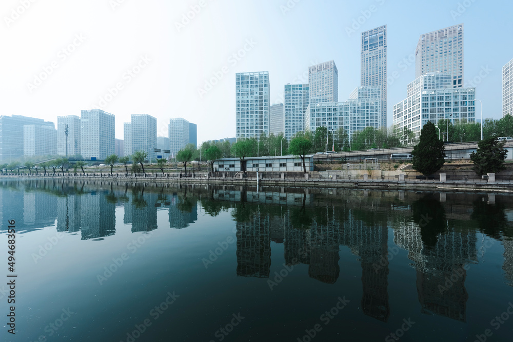 City buildings are reflected on the river