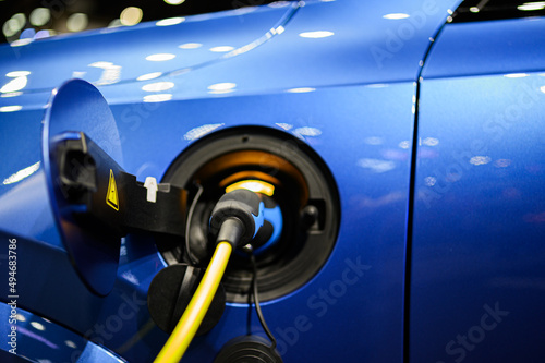 Close up of luxury electric car are using Electric vehicle charger ( EV ) to fully charge before traveling.