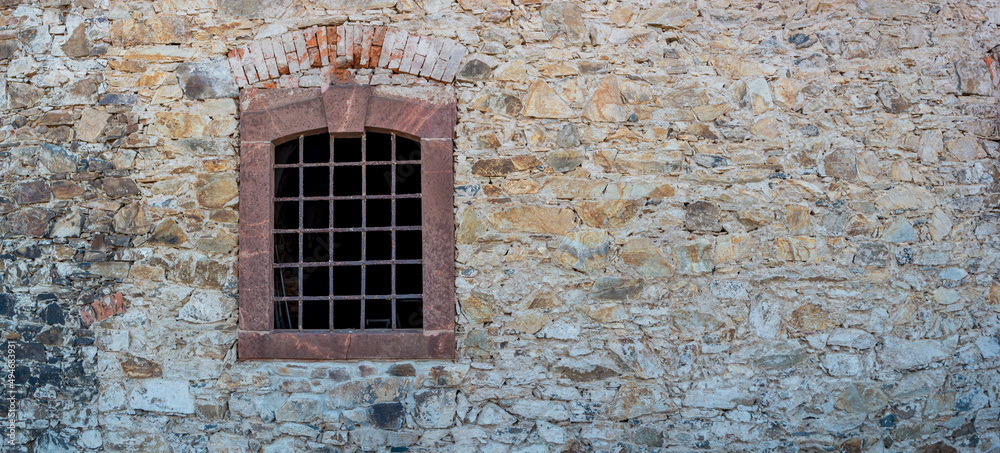 Banner with ancient stone wall and a metal grid window as a prison with copy space background. Concept of freedom and liberty.