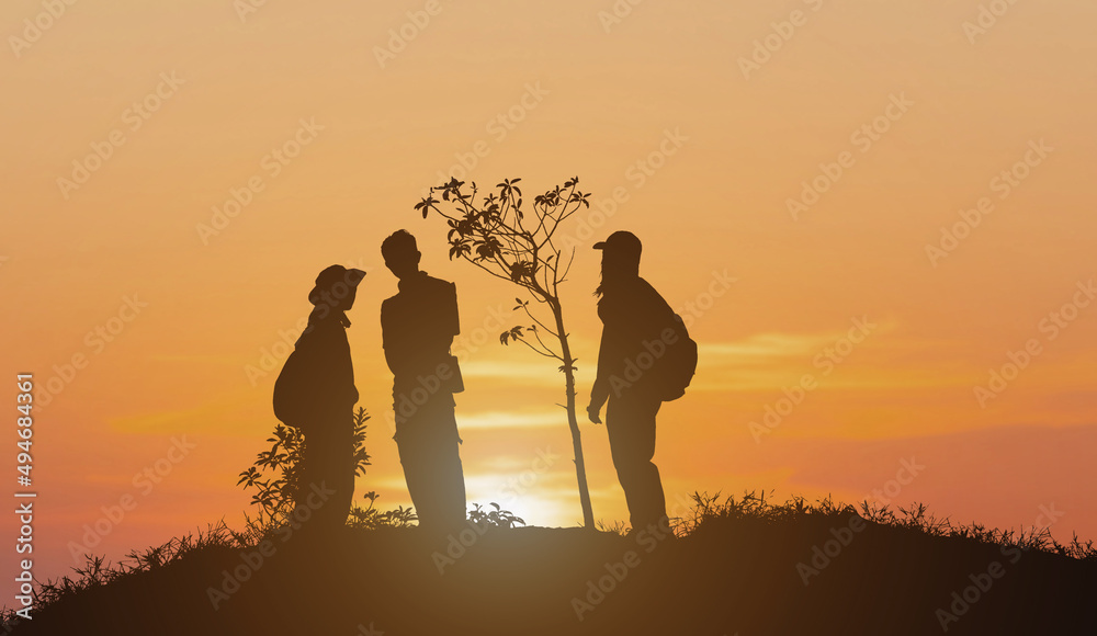 Silhouette group of people standing on mountain sunset background