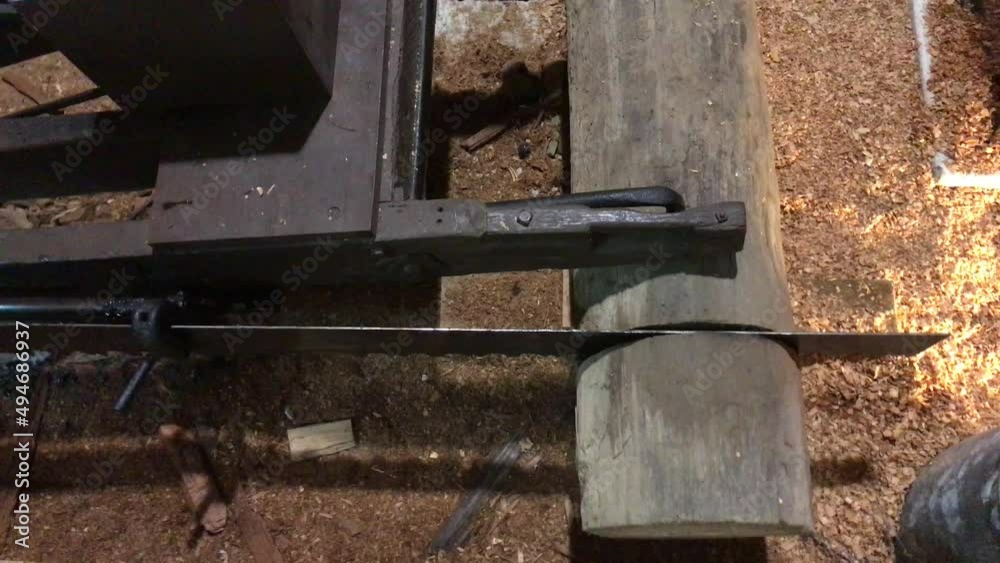 Old electric saw blade at a sawmill cutting through a log of wood Old electric saw blade at a sawmill cutting through a log of wood