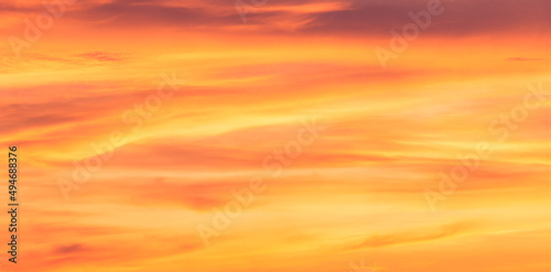 Orange sunrise sky clouds background in the evening, Romantic sky pastel with dramatic yellow clouds fluffy