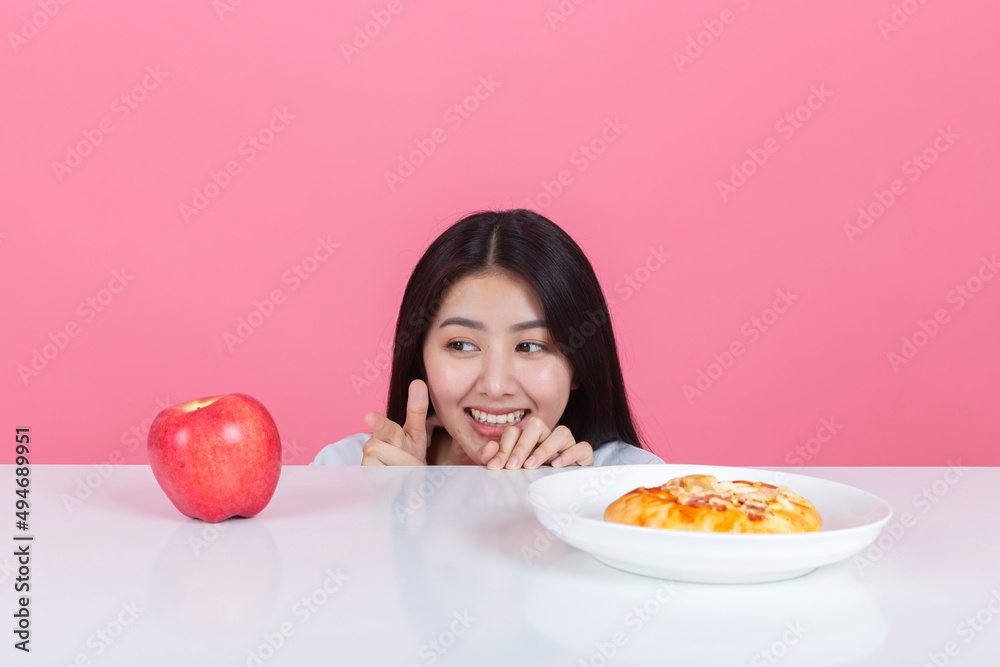 happy young asian woman choose to eat fresh orange apple fruits with copy space pink background, health care eat vegetables and useful foods lifestyles concept. happy young asian woman choose to eat fresh orange apple fruits with copy space pink background, health care eat vegetables and useful foods lifestyles concept.