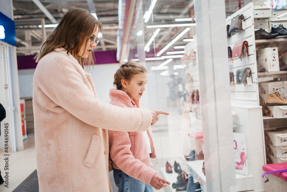 mother and daughter look at the shop window of the shopping day mother and daughter look at the shop window of the shopping day