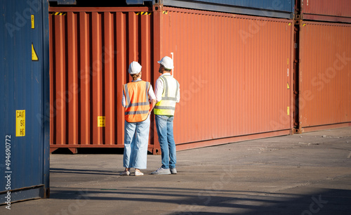 Warehouse cargo business. CEO man and american woman in safety suit help each other holding box and conclude a job for transport and logistics. Businesswoman and businessman at work