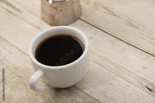 Coffee in a glass on a wooden floor The drink is popular all over the world. Products from Asia and Blasil