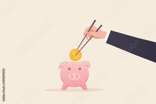 Asian people's savings concept. A businessman's hands hold gold coin chopsticks and drop coins into the piggy bank.