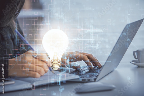 Double exposure of woman hands typing on computer and light bulb drawing. Idea concept.