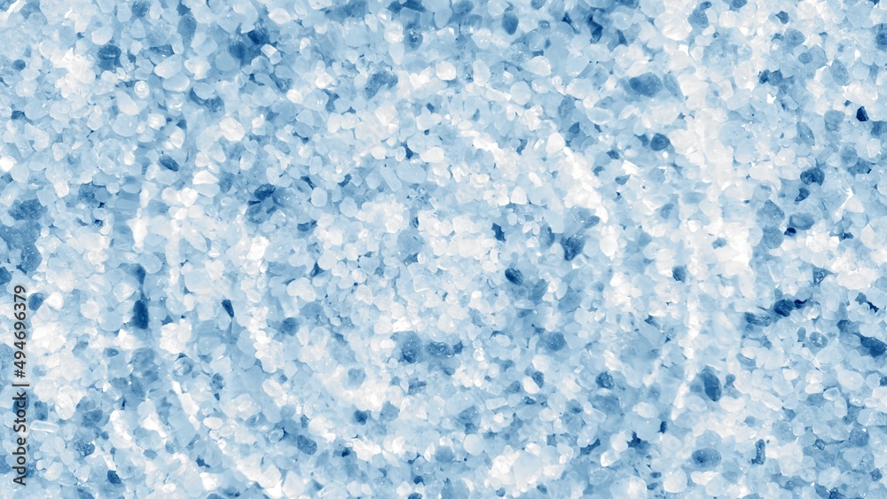 Obraz premium Single water drop making water rings on water surface over blue crystal mineral background | products background, dead sea skin care concept
