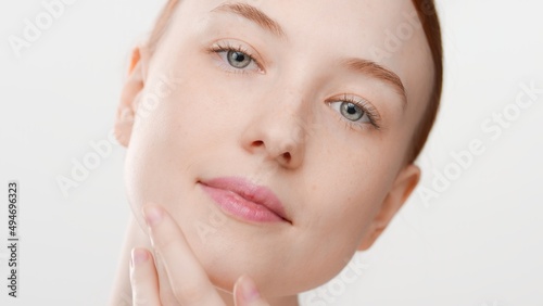 Big close-up beauty portrait of young ginger woman touches her chin   Soft skin commercial concept