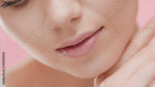 Extreme close up beauty portrait of young Caucasian woman touches her face under chin with back side of her hand   Perfect skin commercial concept