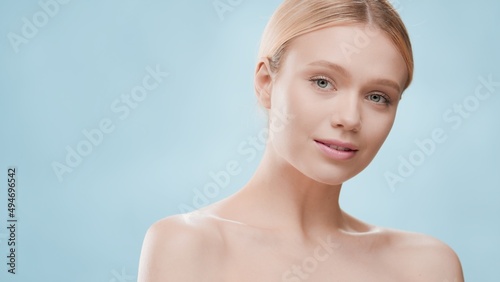 Beauty portrait of young blond gorgeous Caucasian woman against blue background | Skin care concept