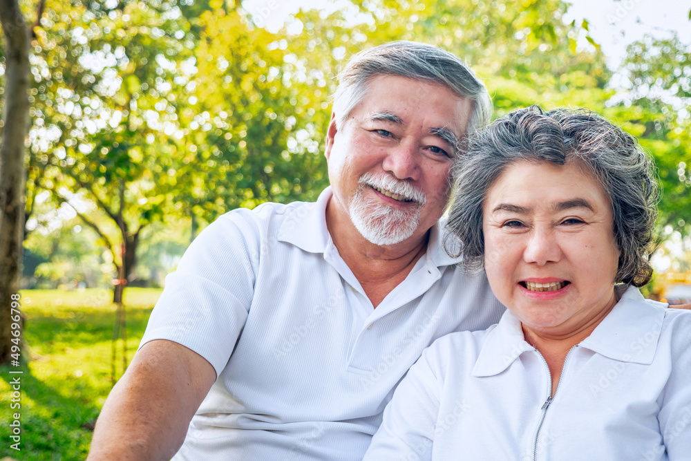 A cheerful elderly couple wearing white shirts, sitting close together in a sunny park, enjoying a beautiful day outdoors.
A cheerful elderly couple wearing white shirts, sitting close together in a sunny park, enjoying a beautiful day outdoors.