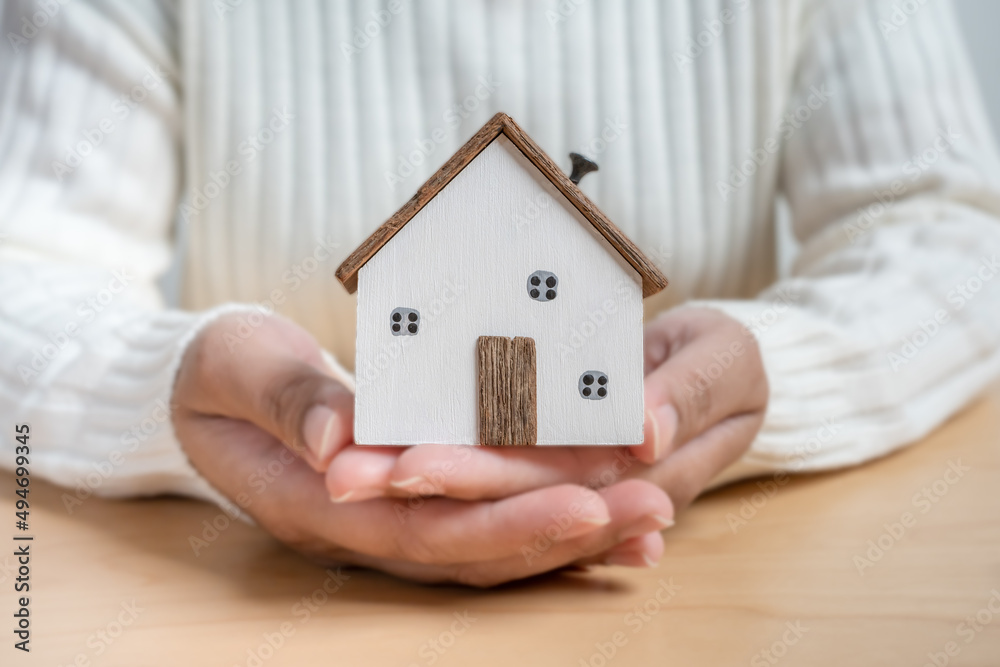 Hands holding small wooden house concept of protection or saving for new residential project. Hands holding small wooden house concept of protection or saving for new residential project.