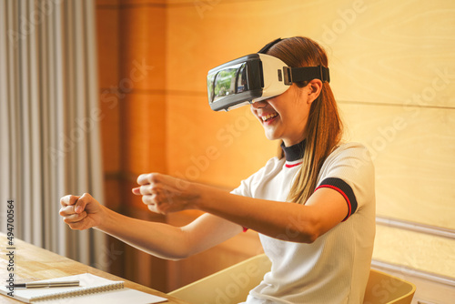 Young Asian woman wearing virtual reality glasses to practice your car driving skills in simulation games.