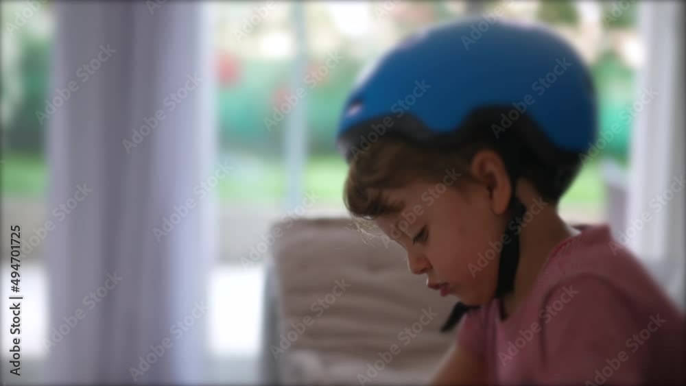 Thoughtful child wearing bike helmet indoor concentrated Thoughtful child wearing bike helmet indoor concentrated