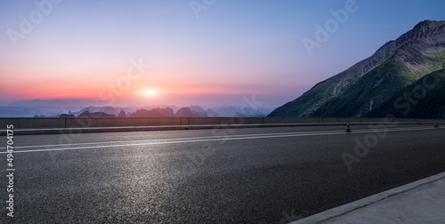 Asphalt highway and mountain natural scenery at sunset. Road and mountain background.