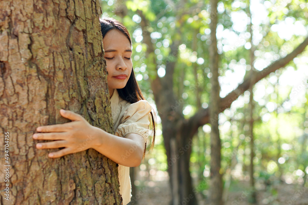 Asian women huging trees , the concept of love for the world Asian women huging trees , the concept of love for the world