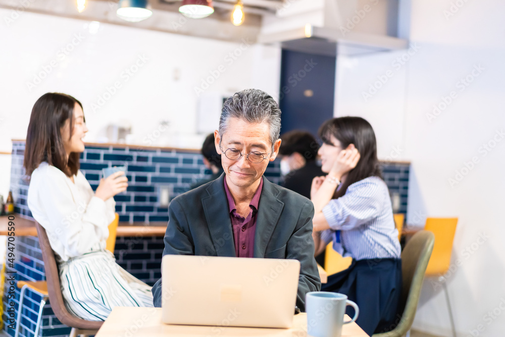 カフェで仕事をする中年男性 カフェで仕事をする中年男性