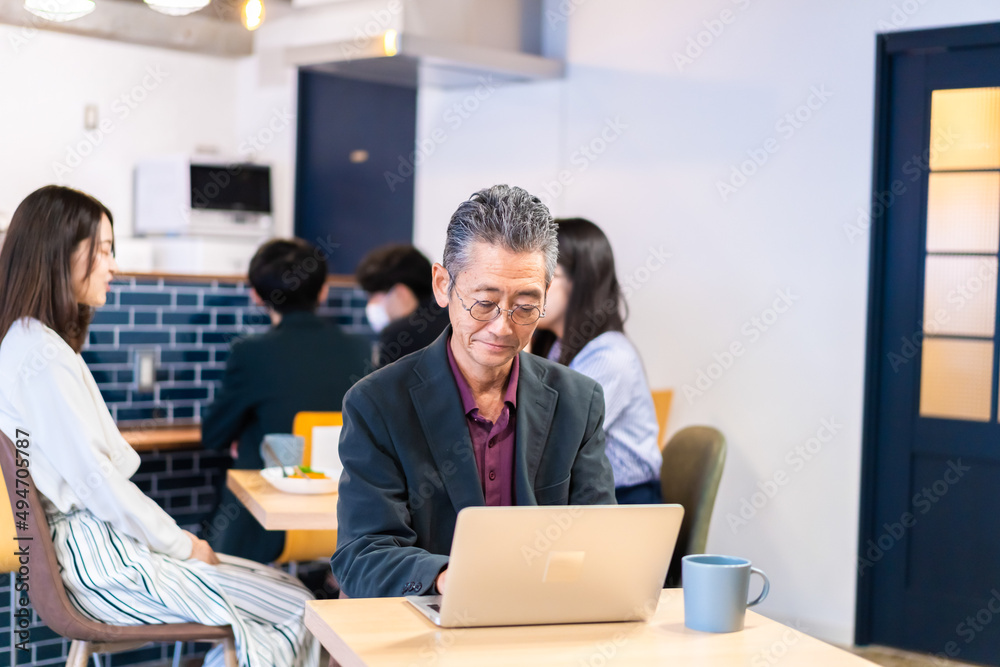カフェで仕事をする中年男性 カフェで仕事をする中年男性
