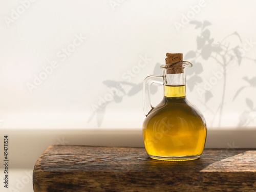 olive oil in glass bottle on wooden board and white background.