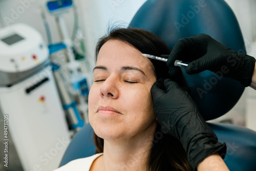 Close up of a woman getting botulinum toxin or fillers on her forehead and face