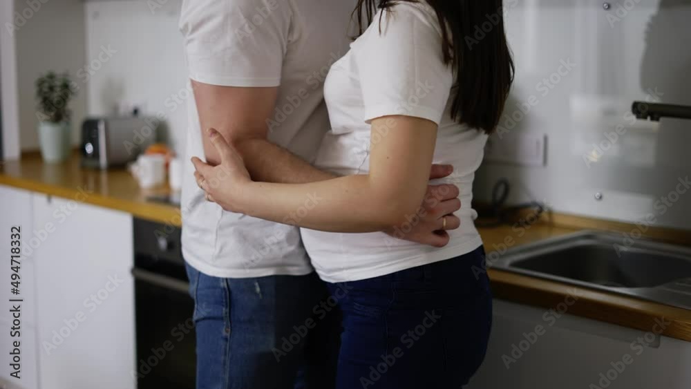 Carefree pregnant woman dancing with loving man in kitchen at home Carefree pregnant woman dancing with loving man in kitchen at home