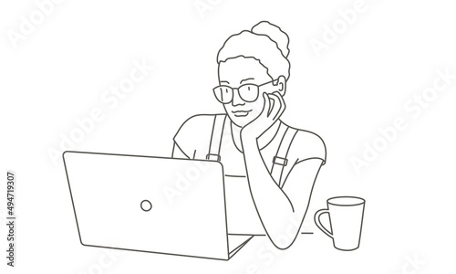 Woman in glasses looks at the data displayed on a laptop.