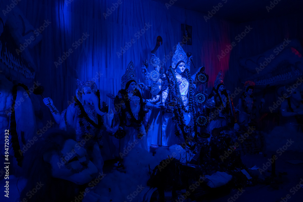 Goddess Durga idol at decorated Durga Puja pandal, shot at colored light, at Kolkata, West Bengal, India. Durga Puja is biggest religious festival of Hinduism and is now celebrated worldwide. - obrazy, fototapety, plakaty 