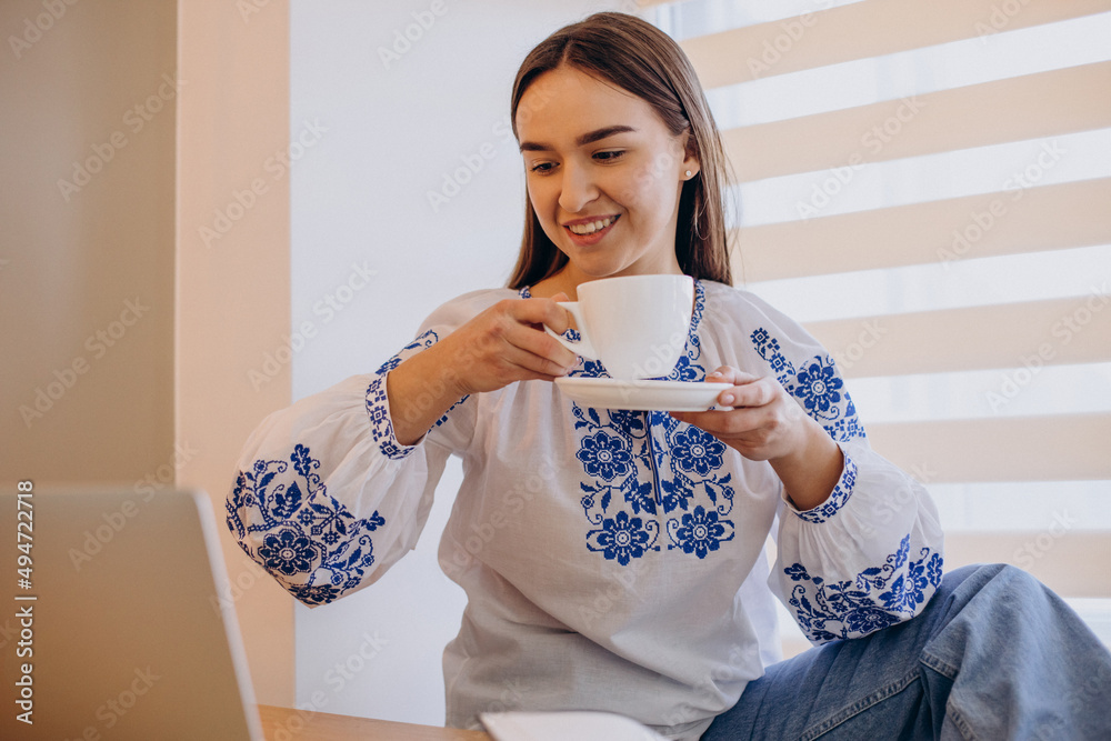 Young ukrainian woman wearing vyshyvanka working from home Young ukrainian woman wearing vyshyvanka working from home
