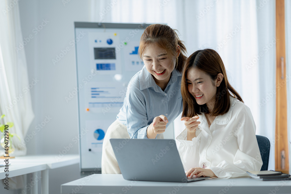 Two Asian women are working together, consulting and brainstorming to analyze data to devise marketing plans for growth companies, start-up executives and employees. Management startup company. Two Asian women are working together, consulting and brainstorming to analyze data to devise marketing plans for growth companies, start-up executives and employees. Management startup company.
