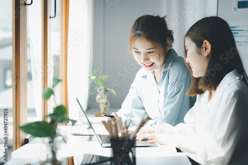 Two Asian women are working together, consulting and brainstorming to analyze data to devise marketing plans for growth companies, start-up executives and employees. Management startup company.