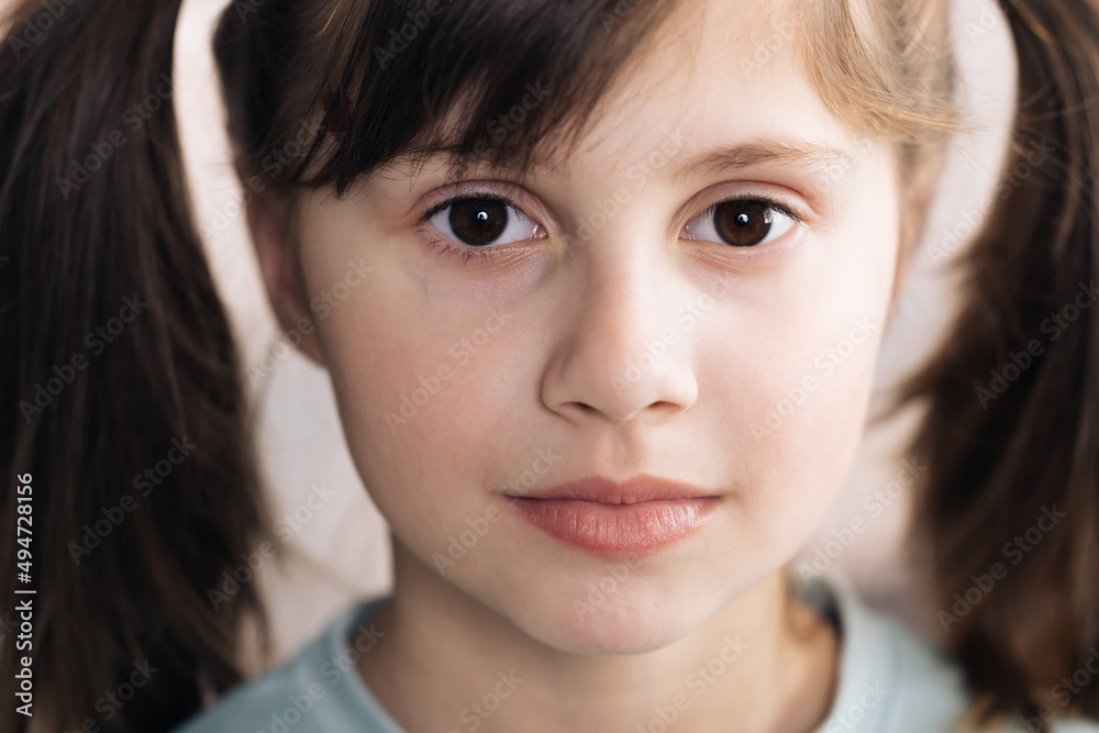 Close-up portrait of caucasian black haired girl isolated home. Adorable child with big brown eyes surprisingly react on something, look at camera. Emotional child. Close-up portrait of caucasian black haired girl isolated home. Adorable child with big brown eyes surprisingly react on something, look at camera. Emotional child.