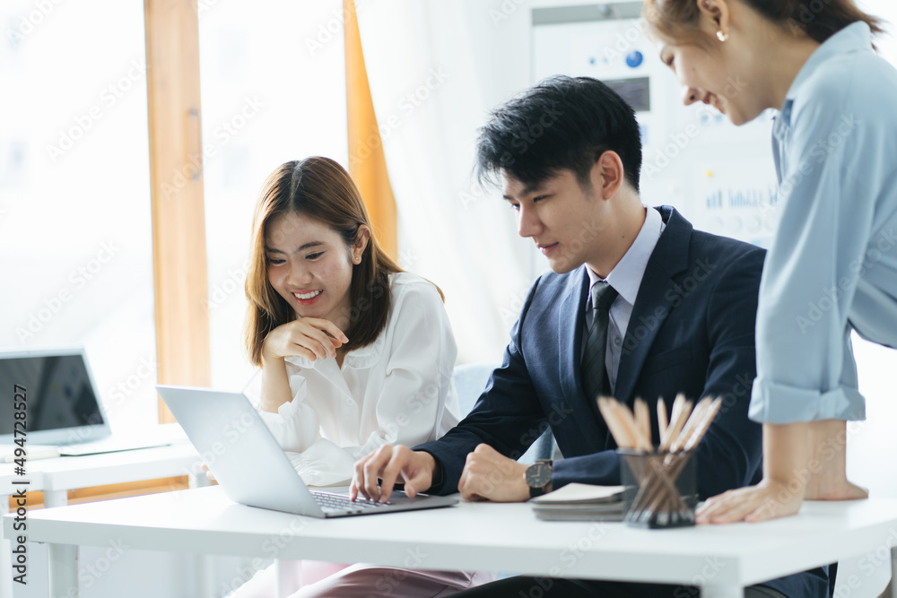 Fototapeta premium Smiling diverse colleagues gather in boardroom brainstorm discuss financial statistics together, happy multiracial coworkers have fun cooperating working together at office meeting, teamwork concept