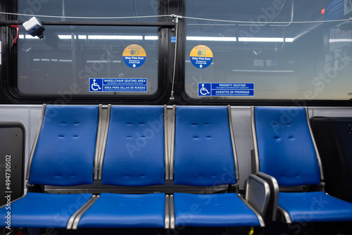 Bus seats inside a bus with disabled stickers