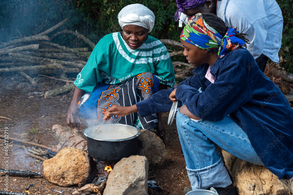 African Teenage girl stirring tea leaves into pot African Teenage girl stirring tea leaves into pot