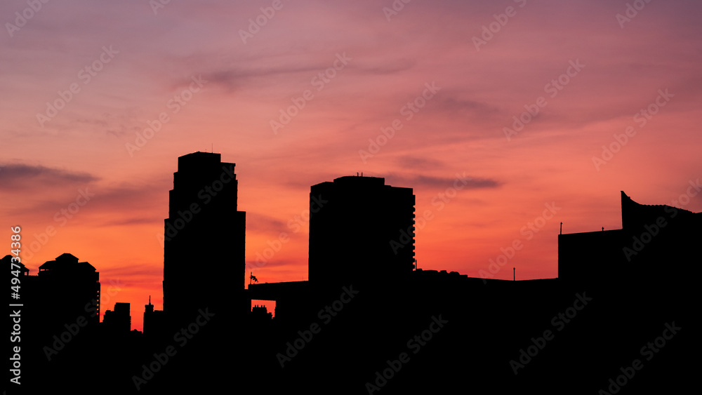 Beautiful color of evening sky with  silhouette buildings as foreground.