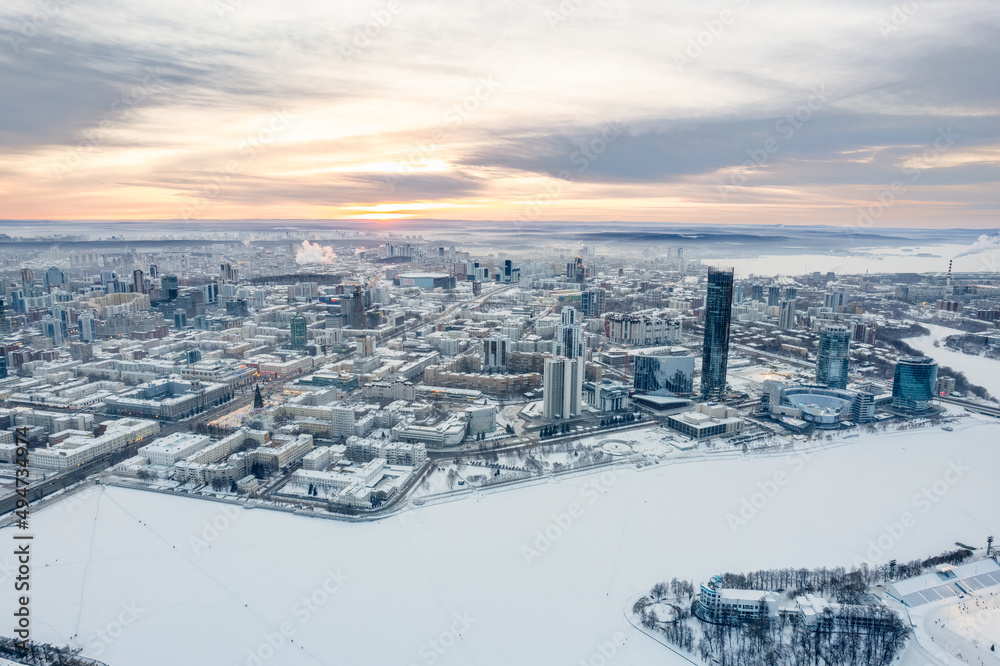 Fototapeta premium Yekaterinburg aerial panoramic view in Winter at sunset. Yekaterinburg city and pond in winter.