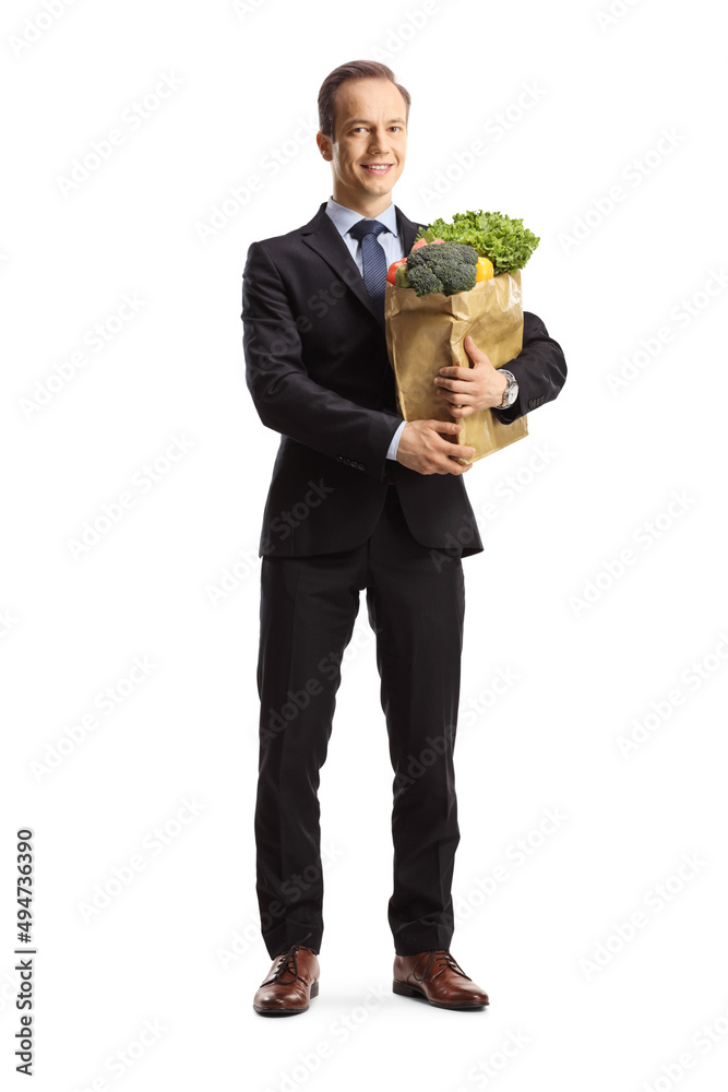 Full length portrait of a bussinesman holding a paper bag with groceries Full length portrait of a bussinesman holding a paper bag with groceries