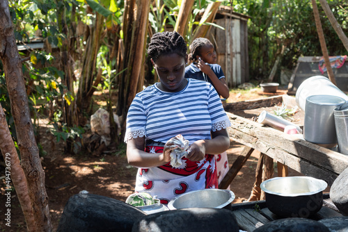 Young African Teenage sisters washing dishes at an outdoor area