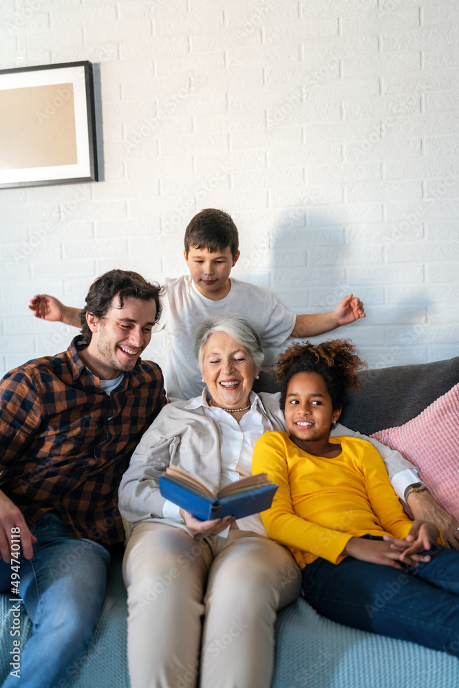 Multi generation multiethnic family reading book, having fun together at home. Multi generation multiethnic family reading book, having fun together at home.